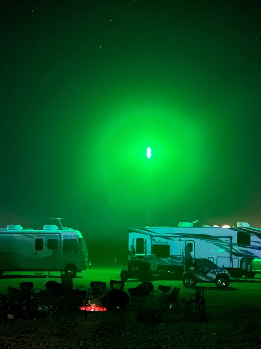 Two RVs parked under a green sky with a bright CAMP LOCATORS.