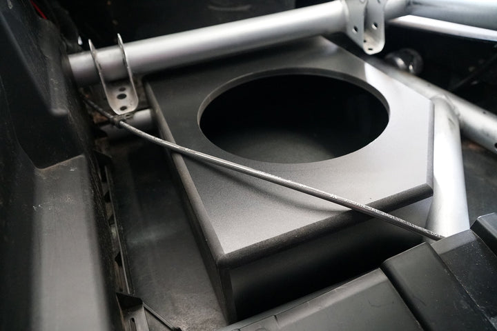 Black subwoofer enclosure box mounted in a vehicle frame