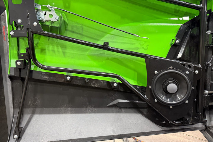 Kawasaki vehicle door interior with black metal frame and mounted audio speaker