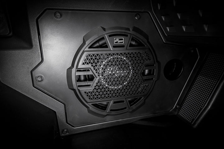 UTV Stereo subwoofer speaker mounted in a black plastic panel