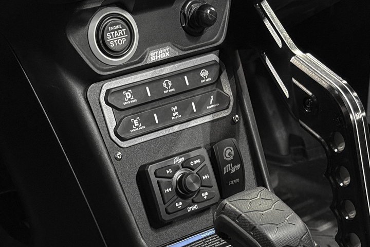 Vehicle center console with engine start stop button drive mode switches and UTV Stereo audio controls