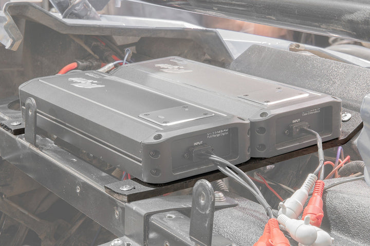 Two MB Quart digital amplifiers mounted in a vehicle chassis with input cables connected
