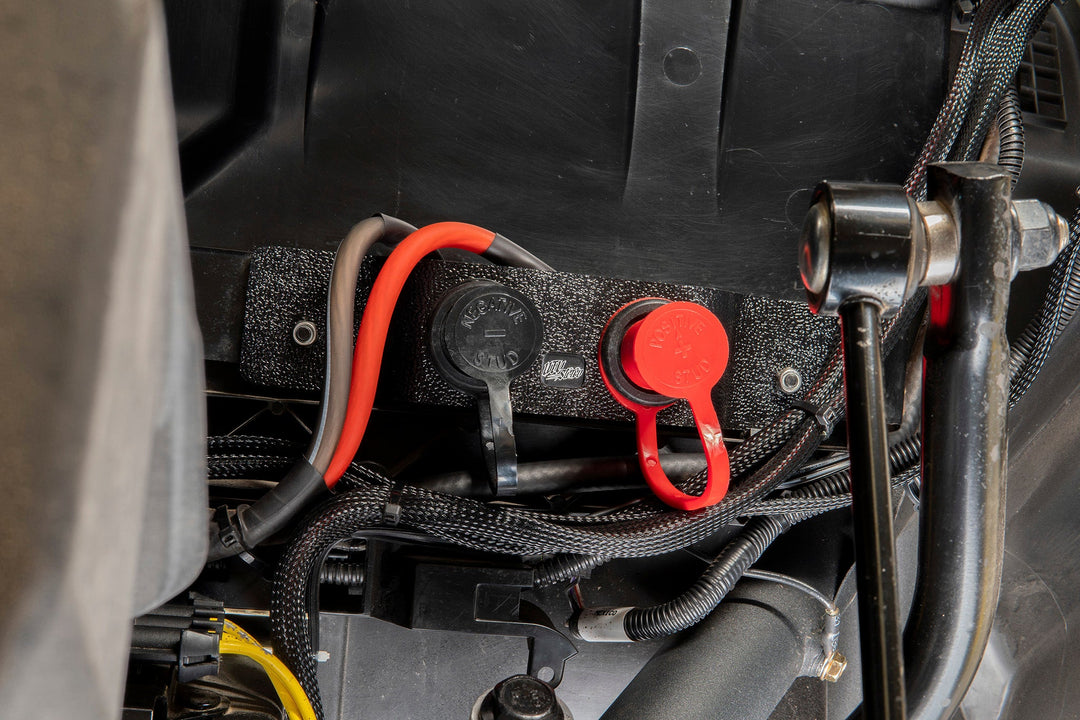 UTV Inc battery terminal stud kit with red and black protective caps installed on vehicle frame