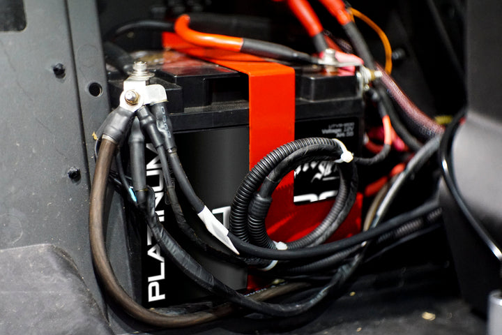 UTV Stereo battery with red mounting bracket and connected wiring