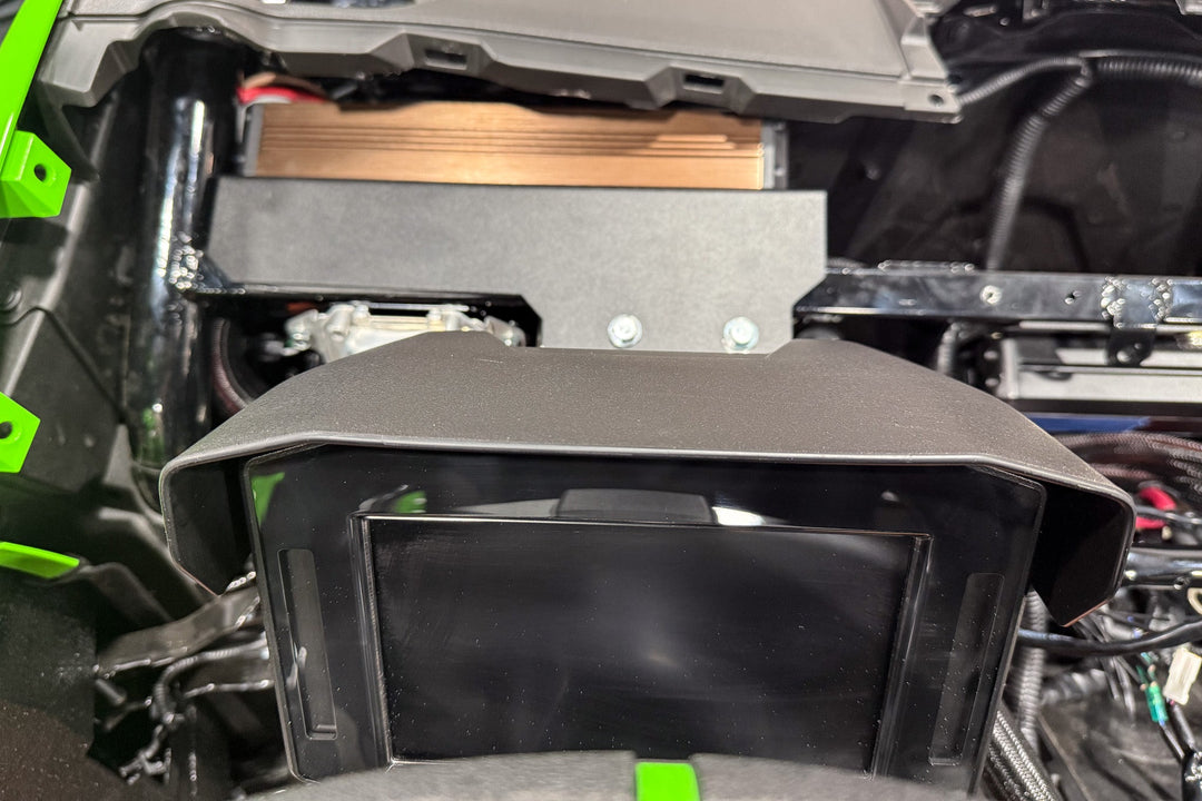 Digital display screen mounted on a vehicle dashboard with a protective hood
