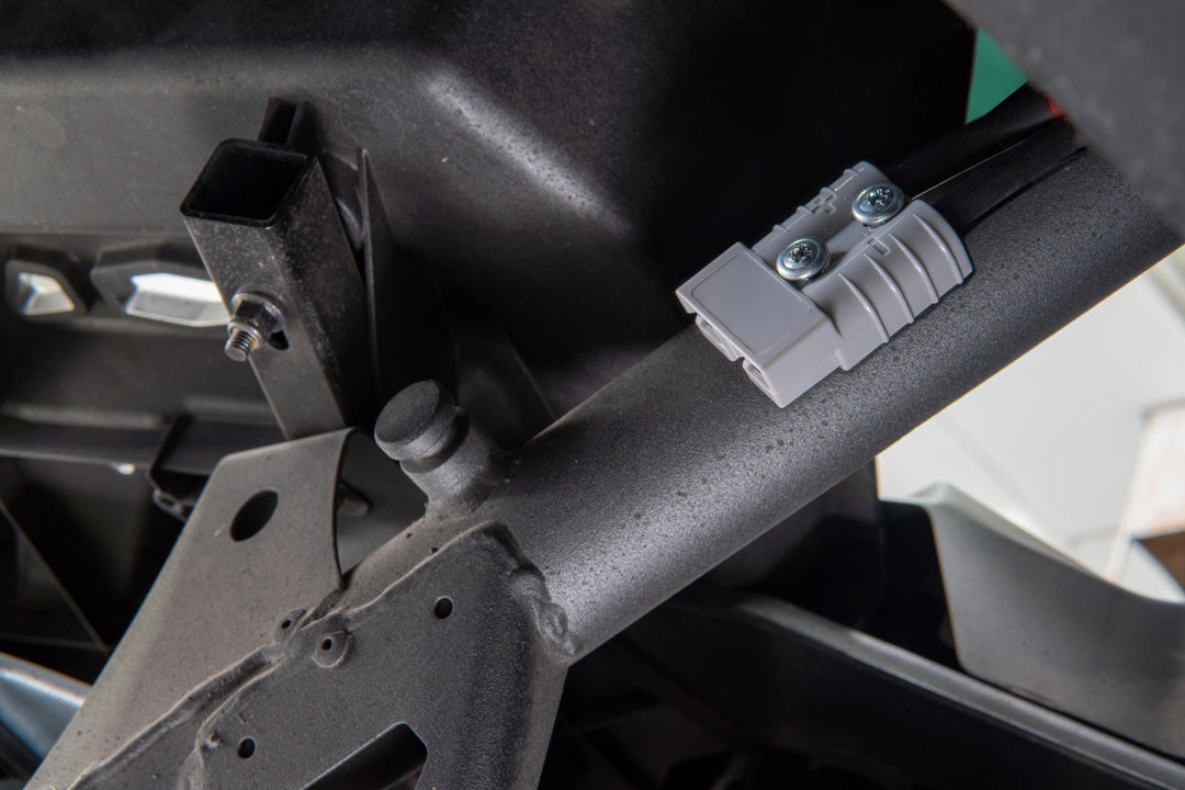 Grey electrical connector mounted on a black metal frame