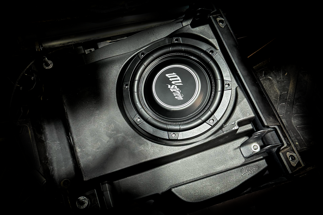UTV Stereo subwoofer installed in a black plastic enclosure