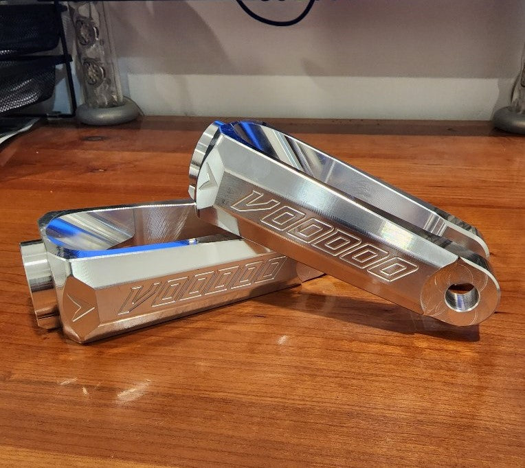 voodoo billet shock fork pair in raw aluminum on wooden desk 